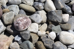 Our River Jack gravels are nominally sized, meaning, typical sizes run 3 to 5 inches representing a middle/average size. There will be some within that size range, that are smaller, and some larger than the nominal size.Delaware Quarries River Jacks are not produced to any ASTM standard, as we sell our product as decorative landscape stone only.  For this example lets use the 3 to 5 inch River Jacks.  The screens are made up of squares, so in the instance of 3 to 5 inch, there is a possibility of a stone up to 7 inch plus, in one dimension if the stone, clearing the screen, if it hits the screen diagonally. This sizes only one dimension of the stone and the other dimension will vary, sometime greatly. In a load of our nominally sized 3 to 5 inch River Jacks, a small percentage may be smaller or larger due to the nature of quarrying and loading.  This process results in our nominally sized River Jacks.