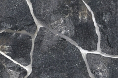 The color range of Southern Eclipse is a glossy black with fine mica pieces. There are occasional streaks of white quartzite and rust tones.. Hand-Split Thin Veneer ranges in thickness from 1" to 3" with a nominal face range of 6" to 18". Average coverage is approximately 100 to 110 square feet per ton. A brick ledge of 4" to 6" is recommended when laying this product as a facade. Packaged in 1-ton Pallets.